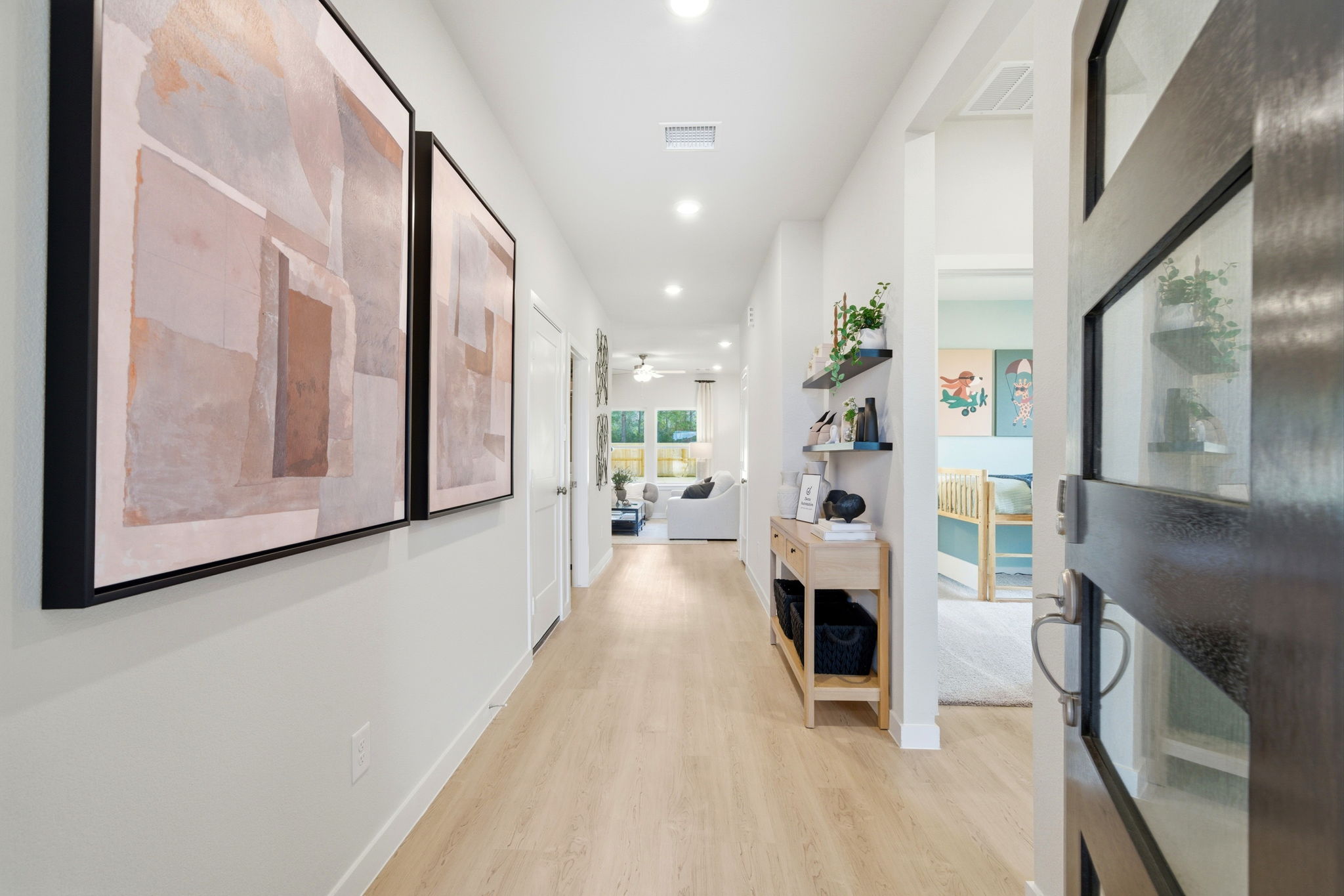 A hallway with a wood floor and a wood floor with a bookcase and a bookcase.
