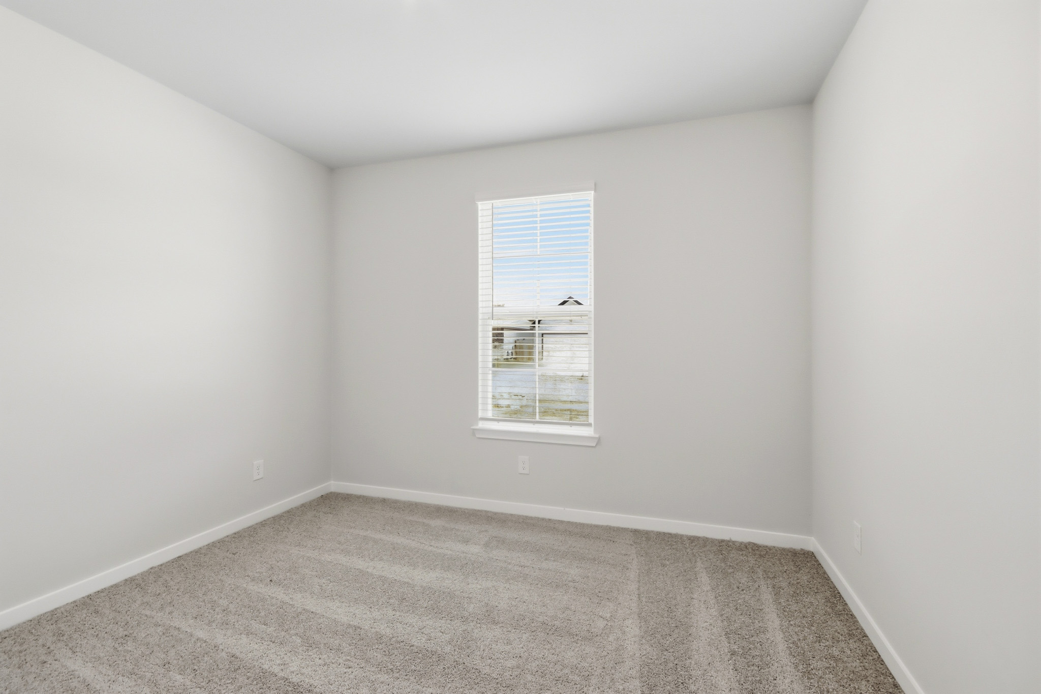 A room with a window and a rug.