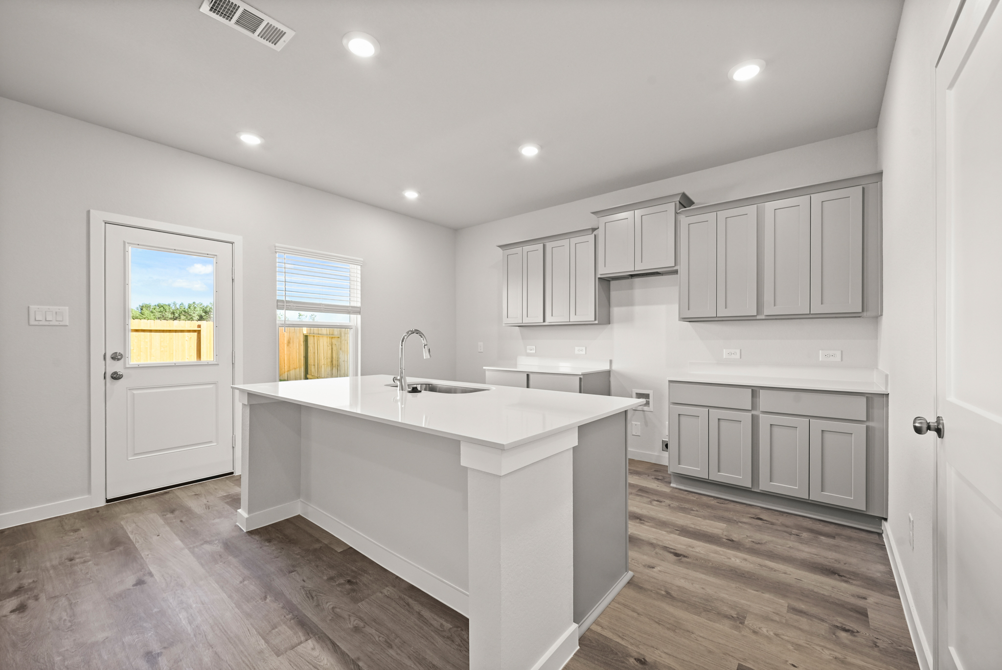 A kitchen with white cabinets.