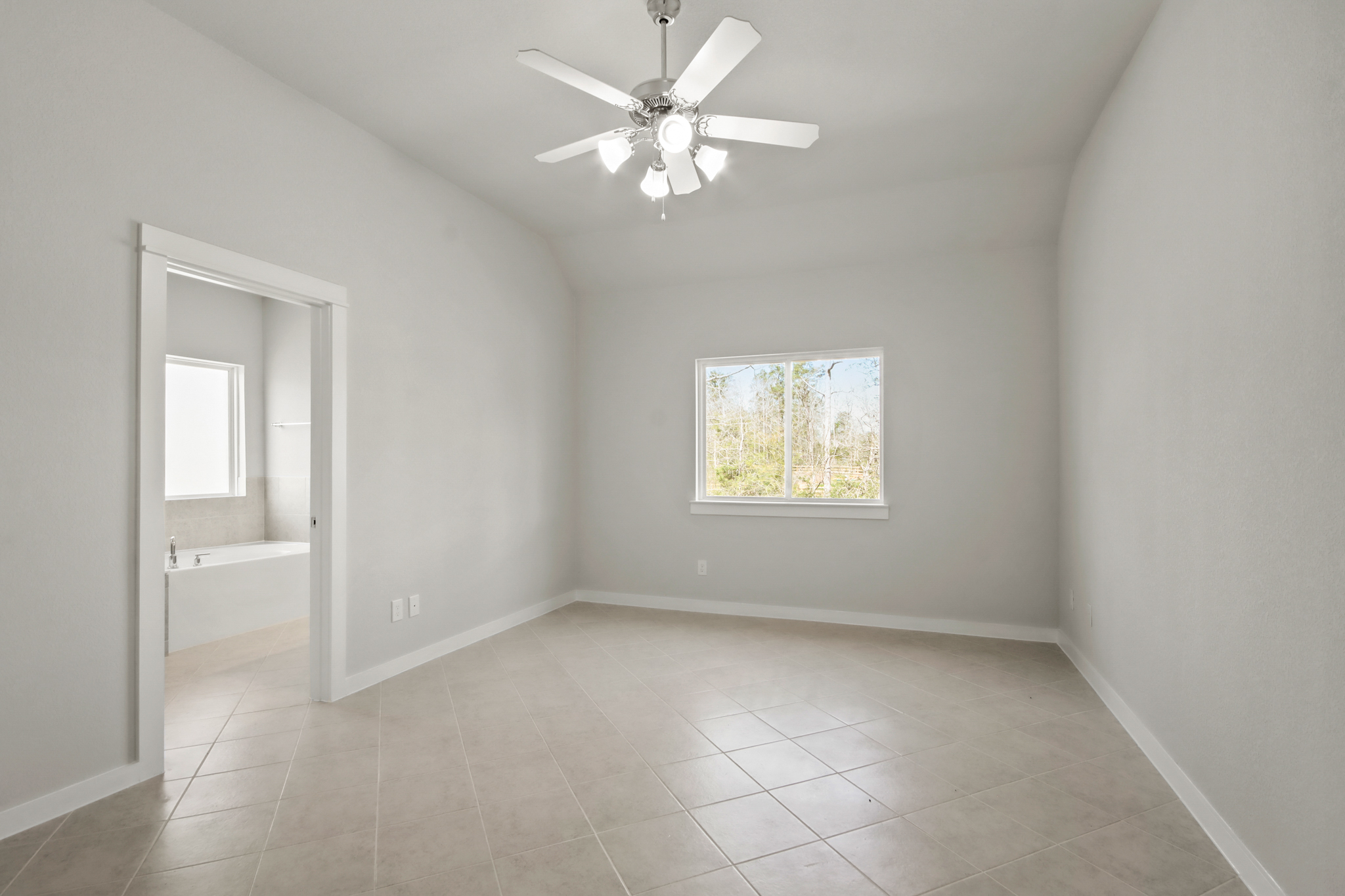 A room with a ceiling fan and a window.
