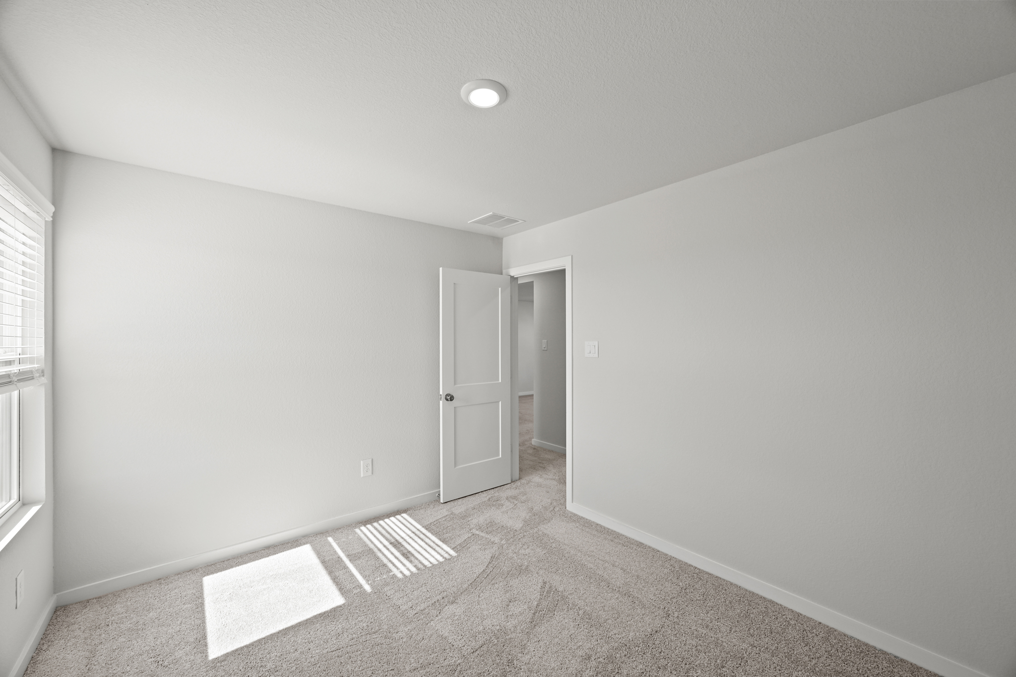 A room with a carpet and a door.