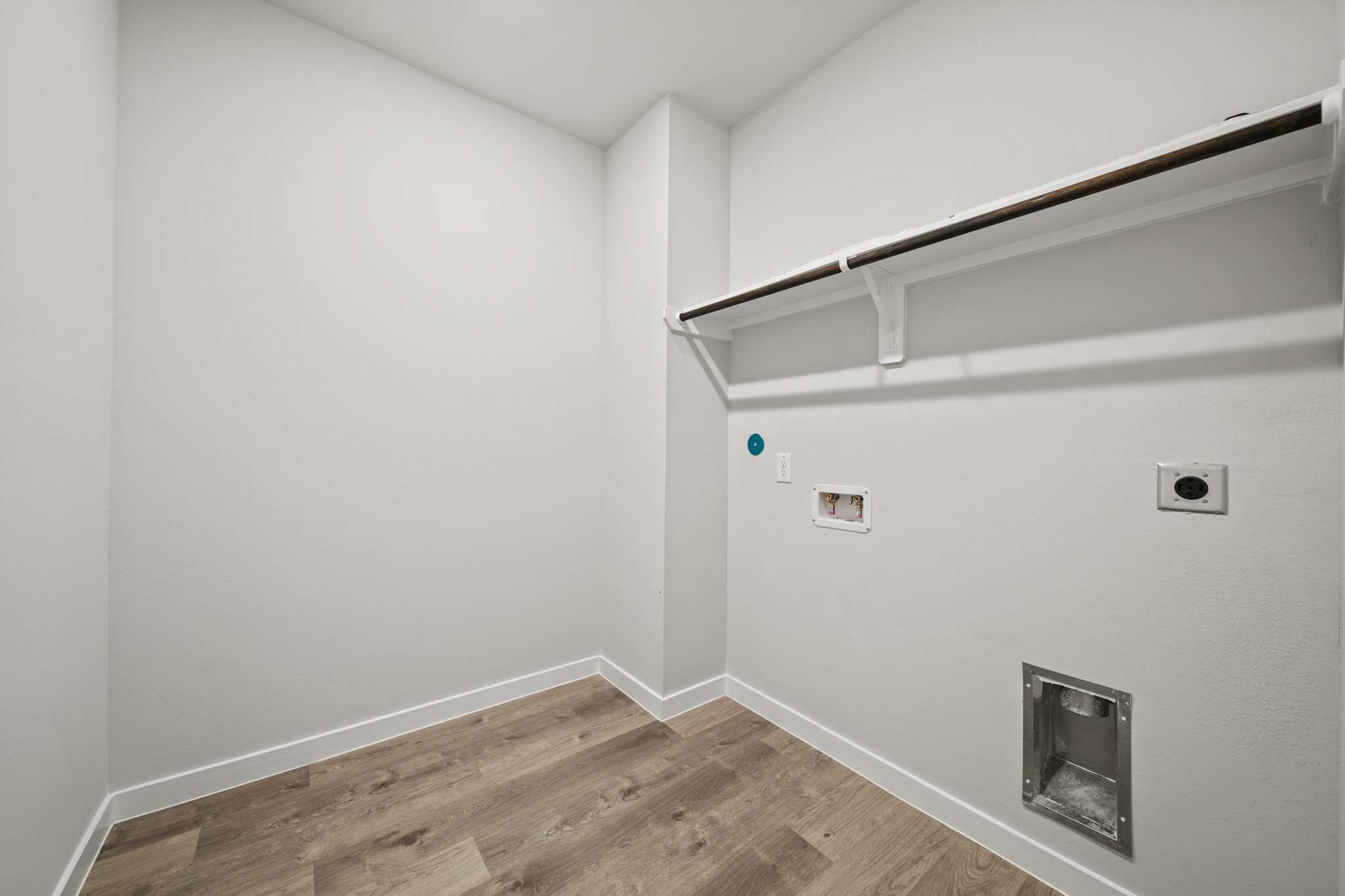 A white room with a wood floor.