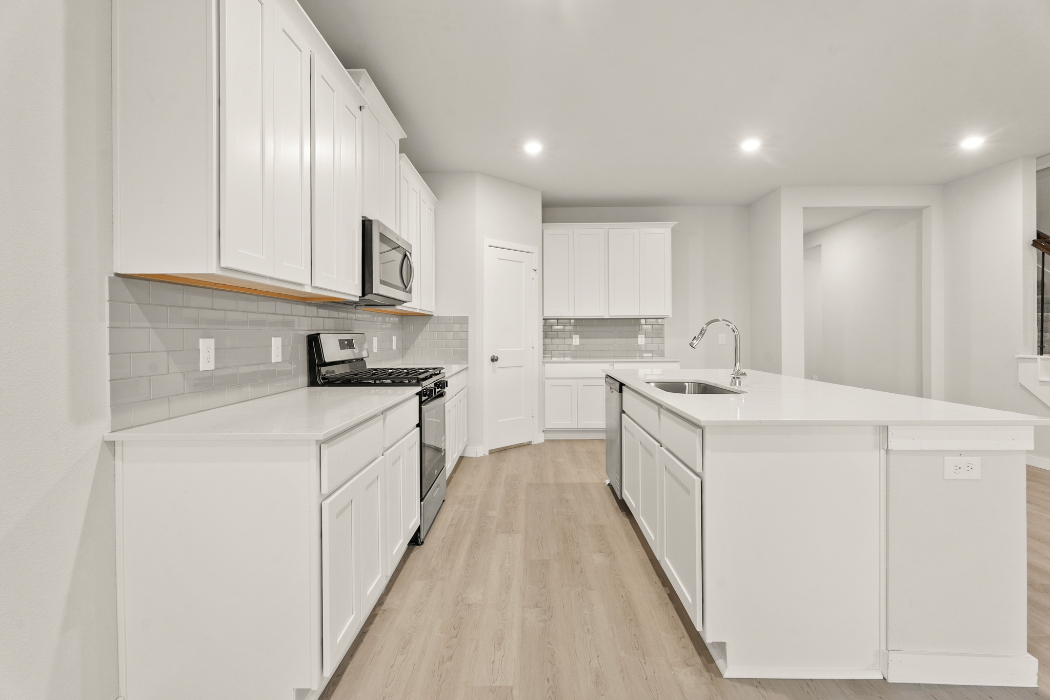A kitchen with white cabinets.