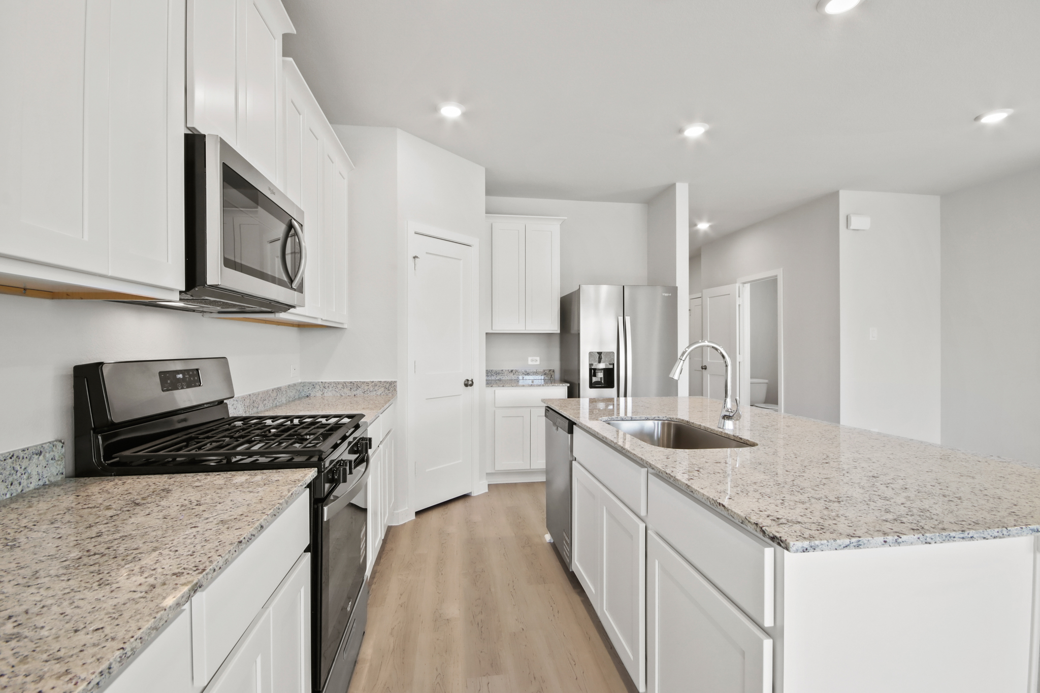 A kitchen with white cabinets.