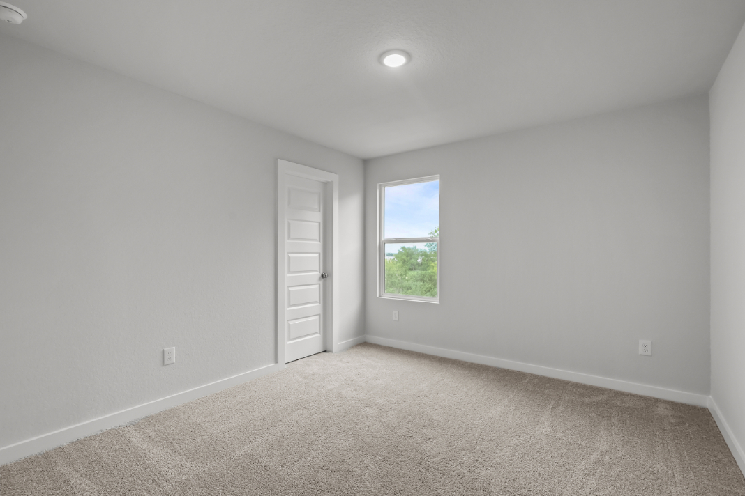 A room with a window and carpet.