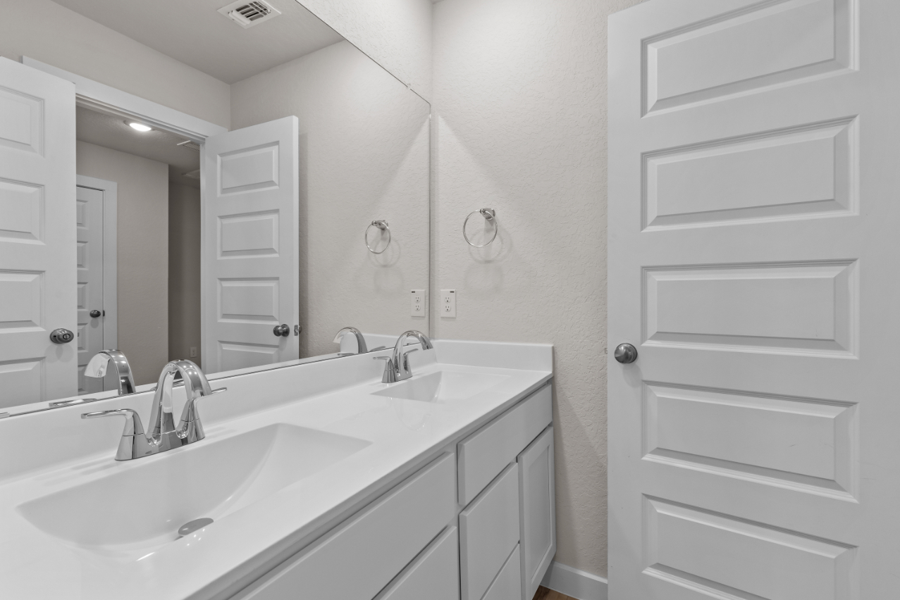 A bathroom with a large mirror.