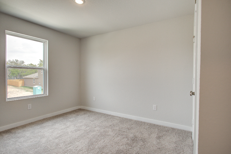 A room with a carpet and a window.