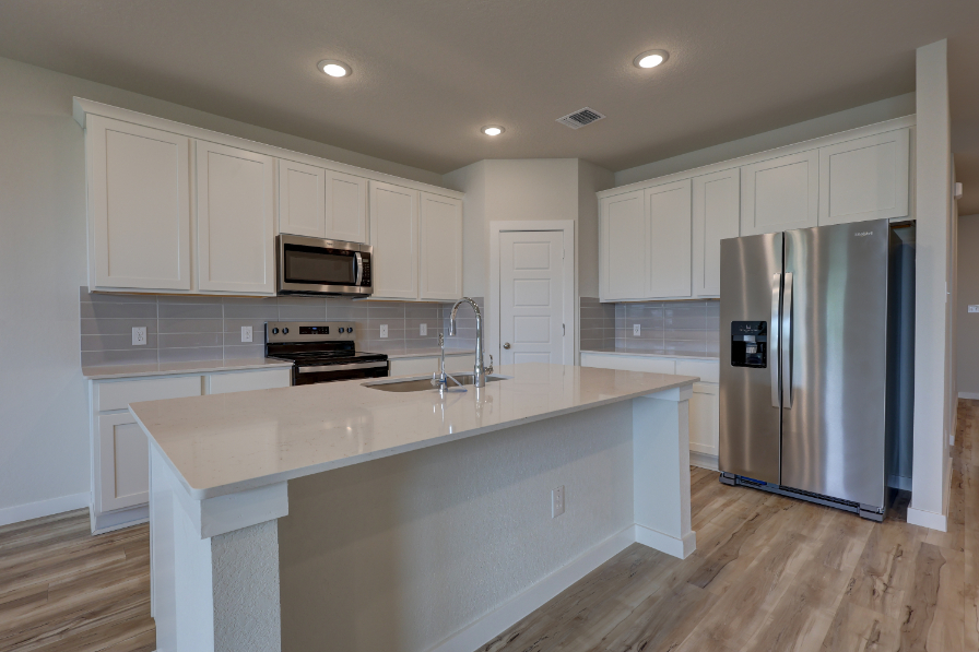 A kitchen with white cabinets.
