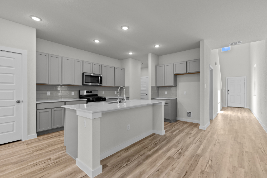 A kitchen with white cabinets.