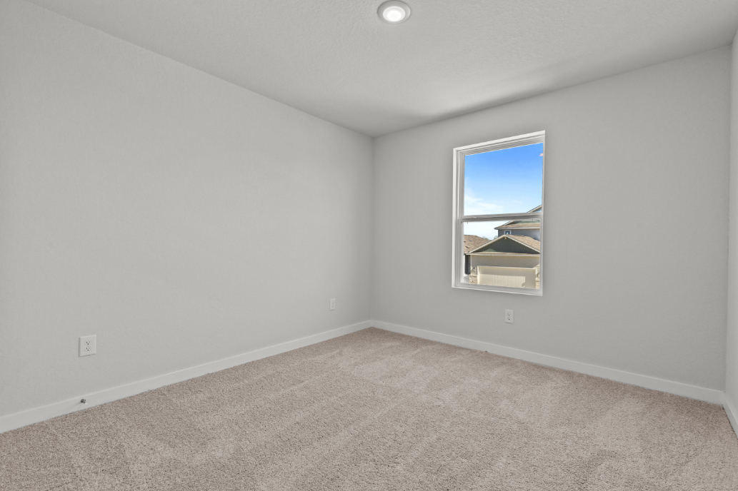 A room with a window and carpet.