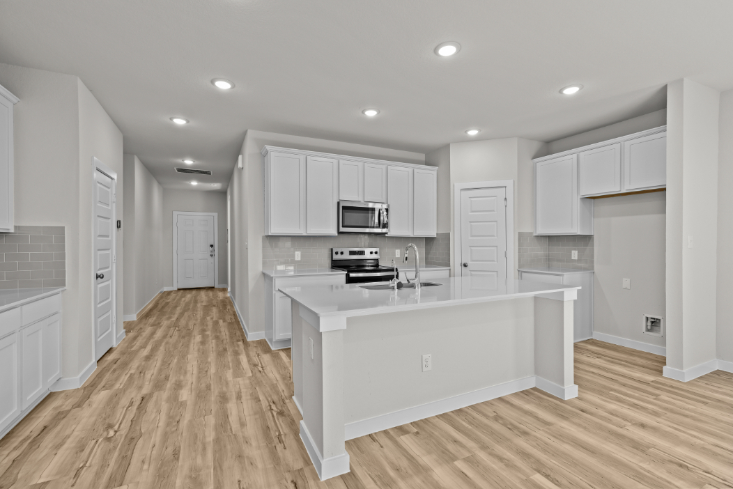 A kitchen with white cabinets.