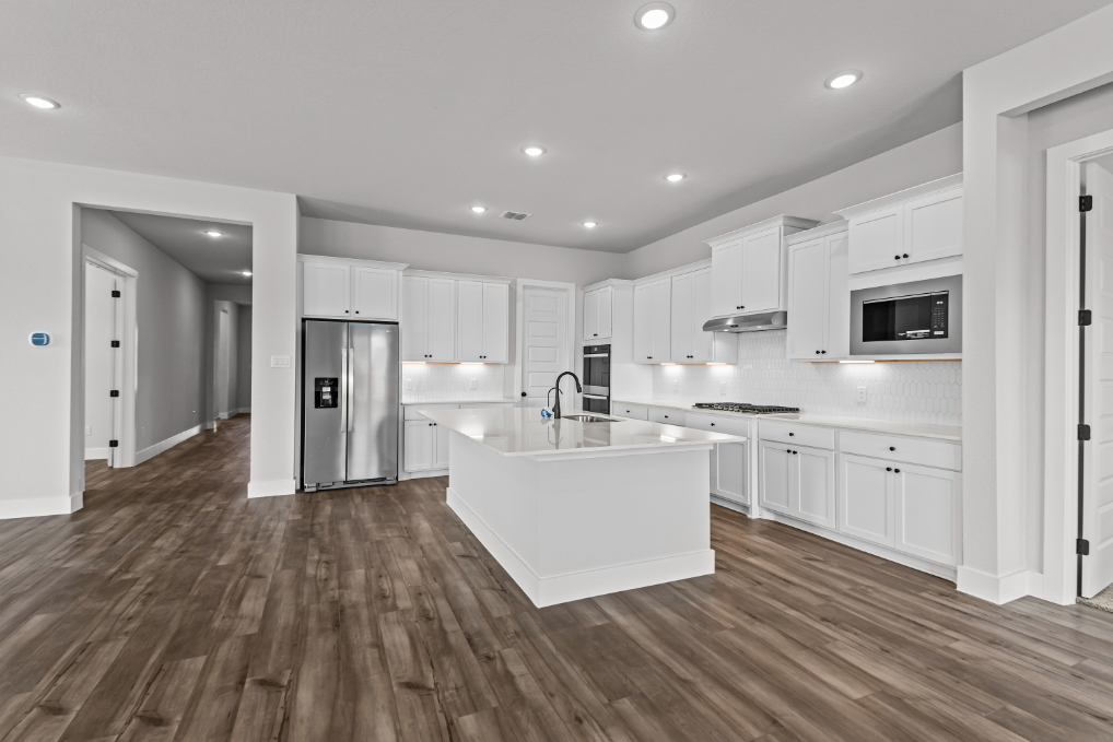 A kitchen with white cabinets.