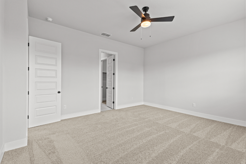 A room with a ceiling fan and a door.