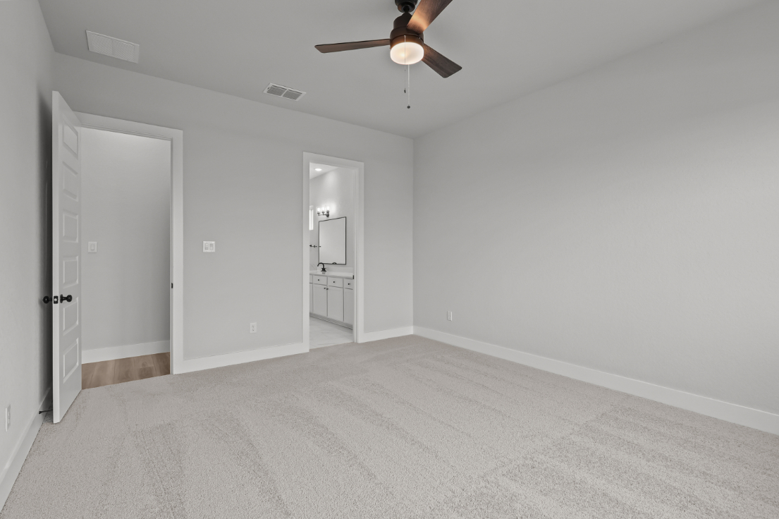 A room with a ceiling fan and a door.