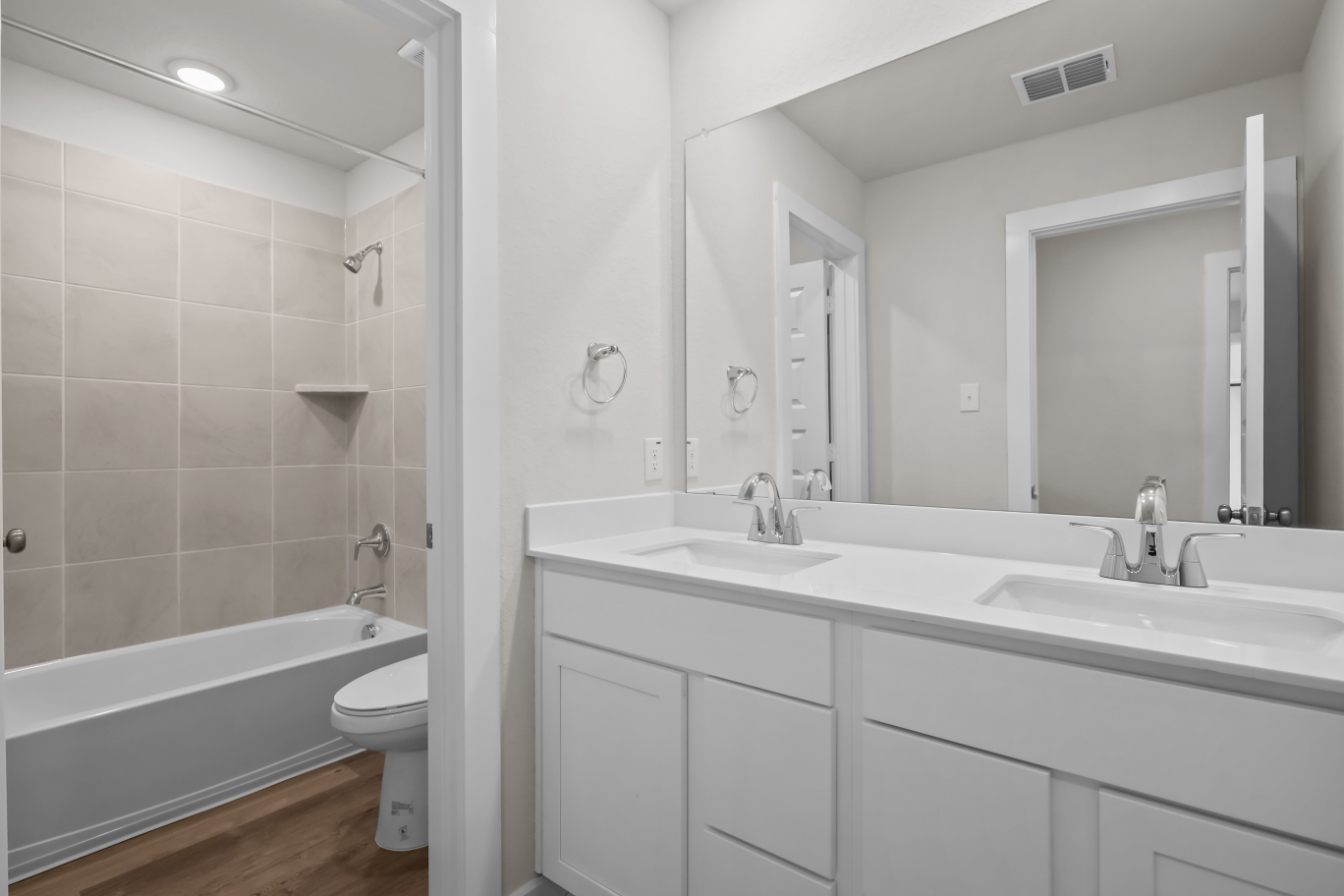 A bathroom with a tub sink and toilet.
