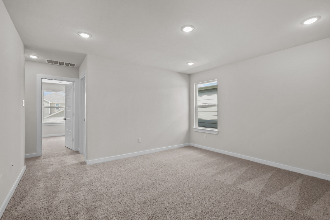 A room with a carpet and a door.