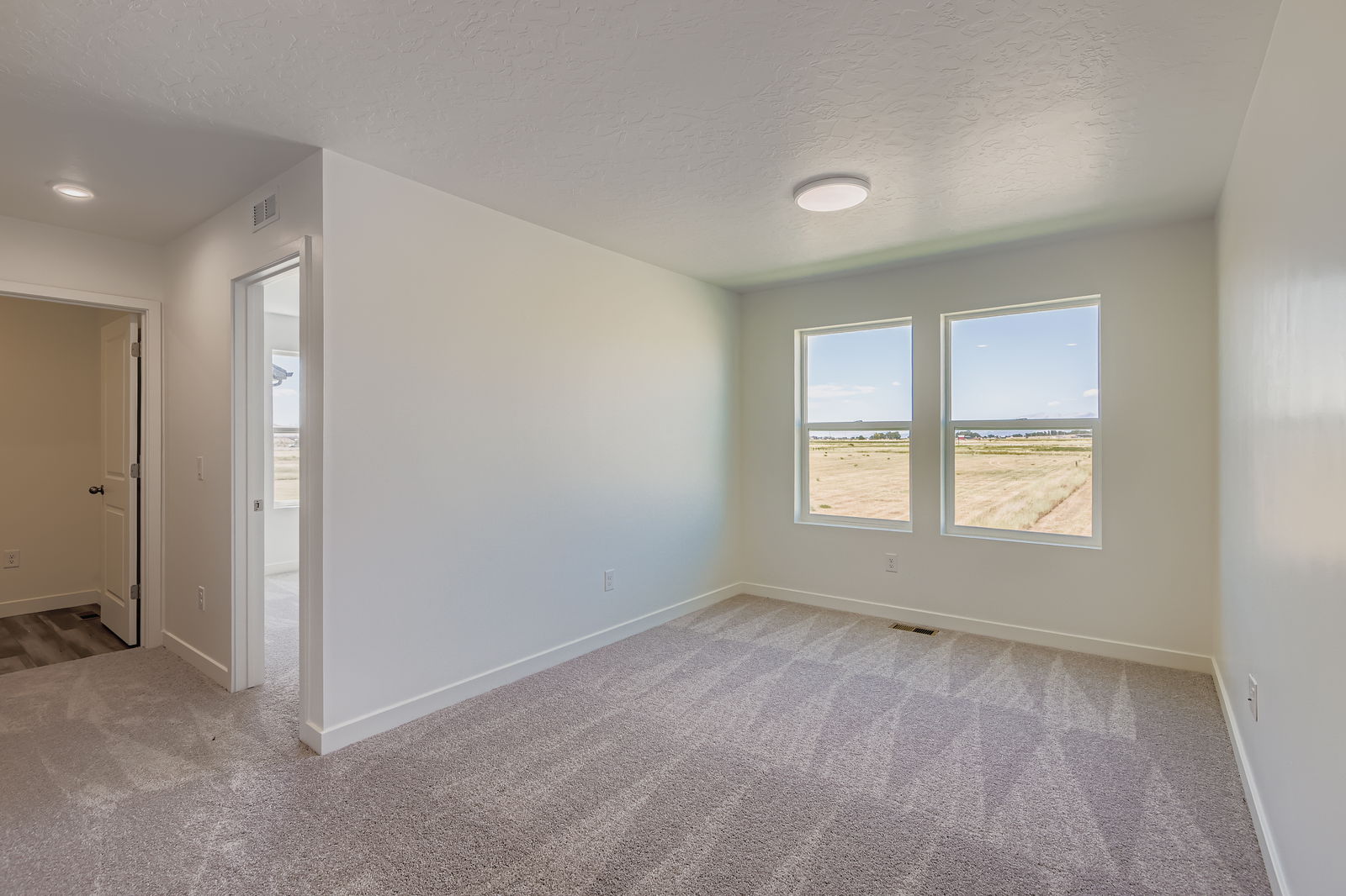 A room with a carpet and a window.