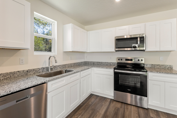 A kitchen with white cabinets.