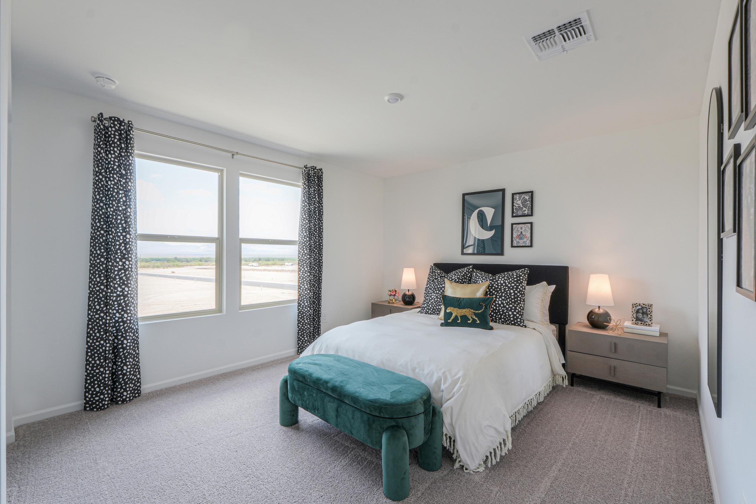 A bedroom with a bed and a bench.