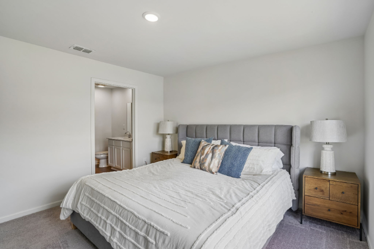 A bedroom with a bed and lamps.