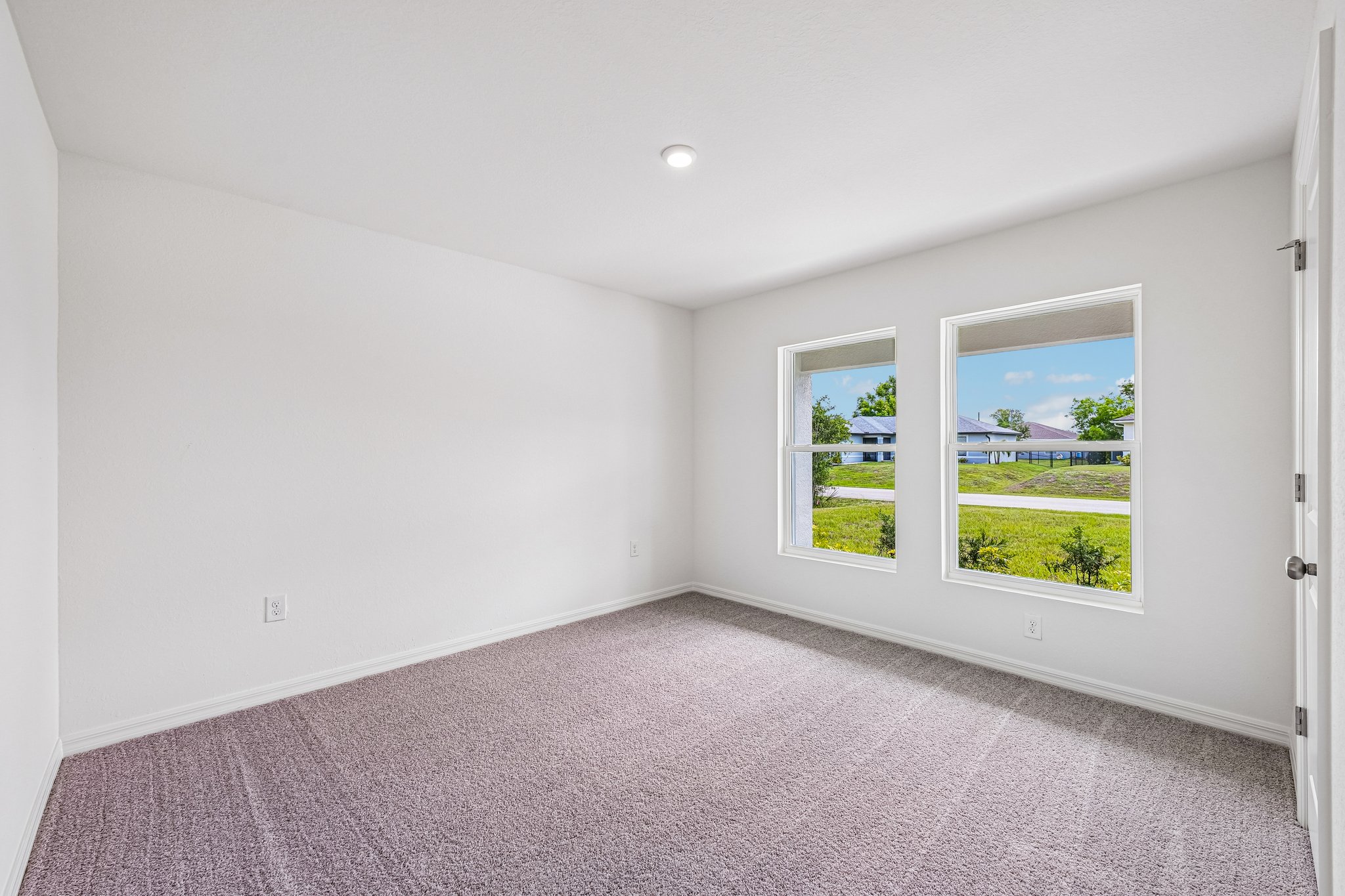 A room with a window and a carpet.