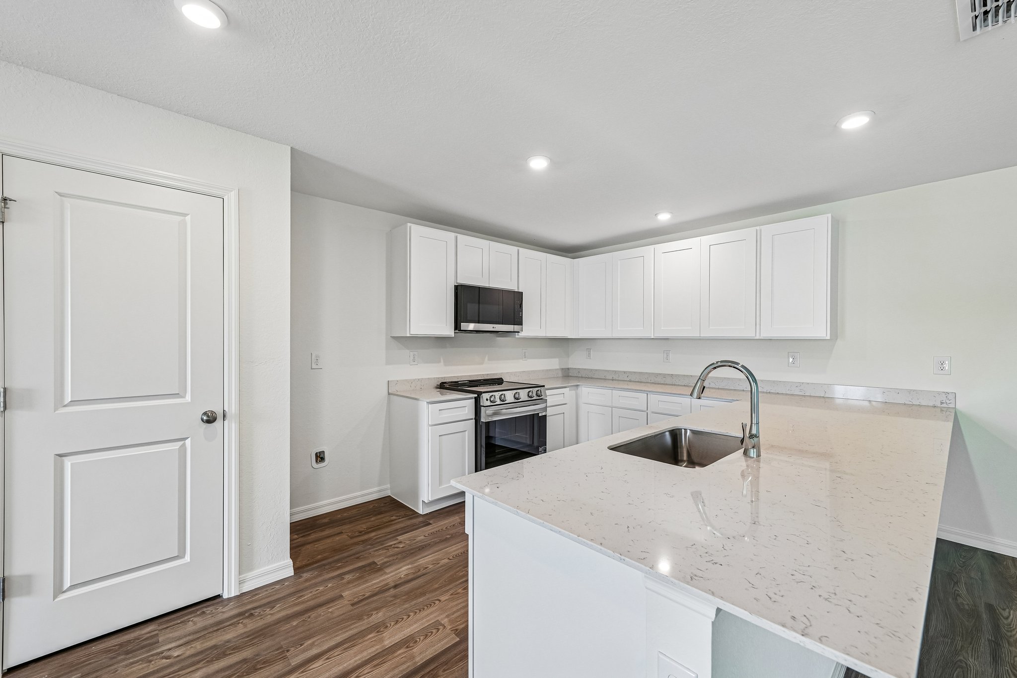 A kitchen with white cabinets.
