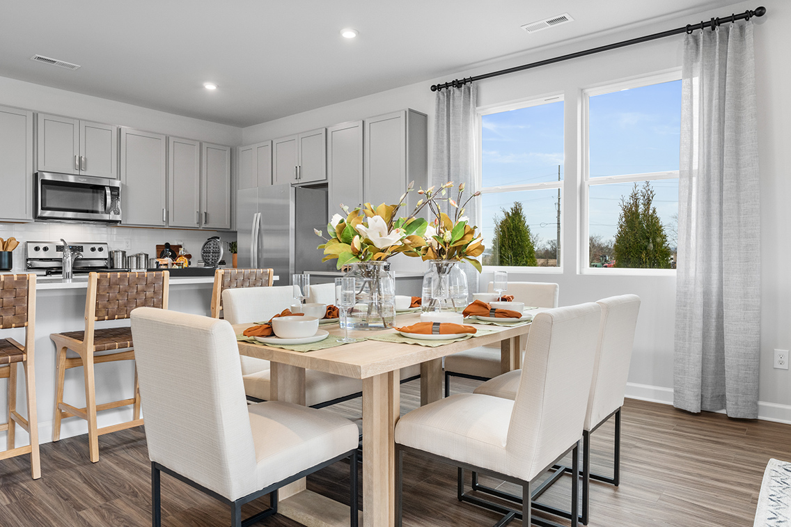 A kitchen with a dining table and chairs.
