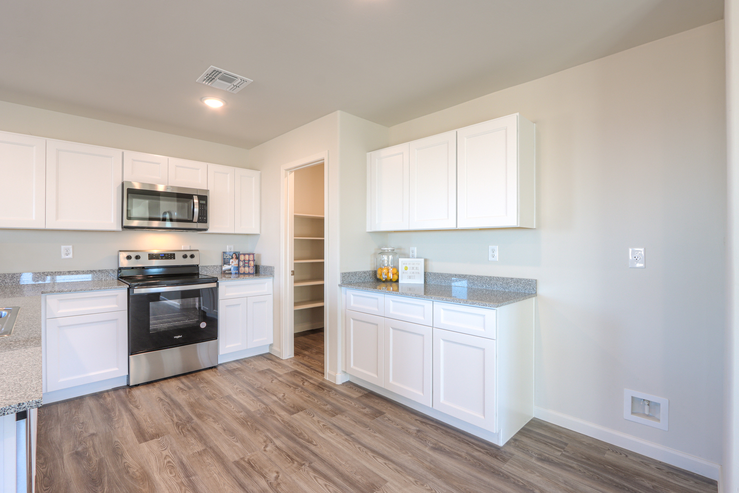 A kitchen with white cabinets.