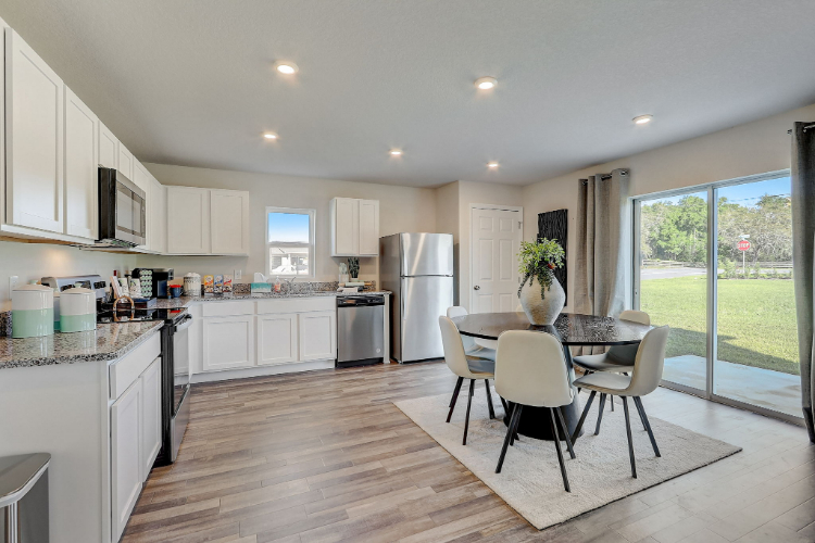A kitchen with a table and chairs.