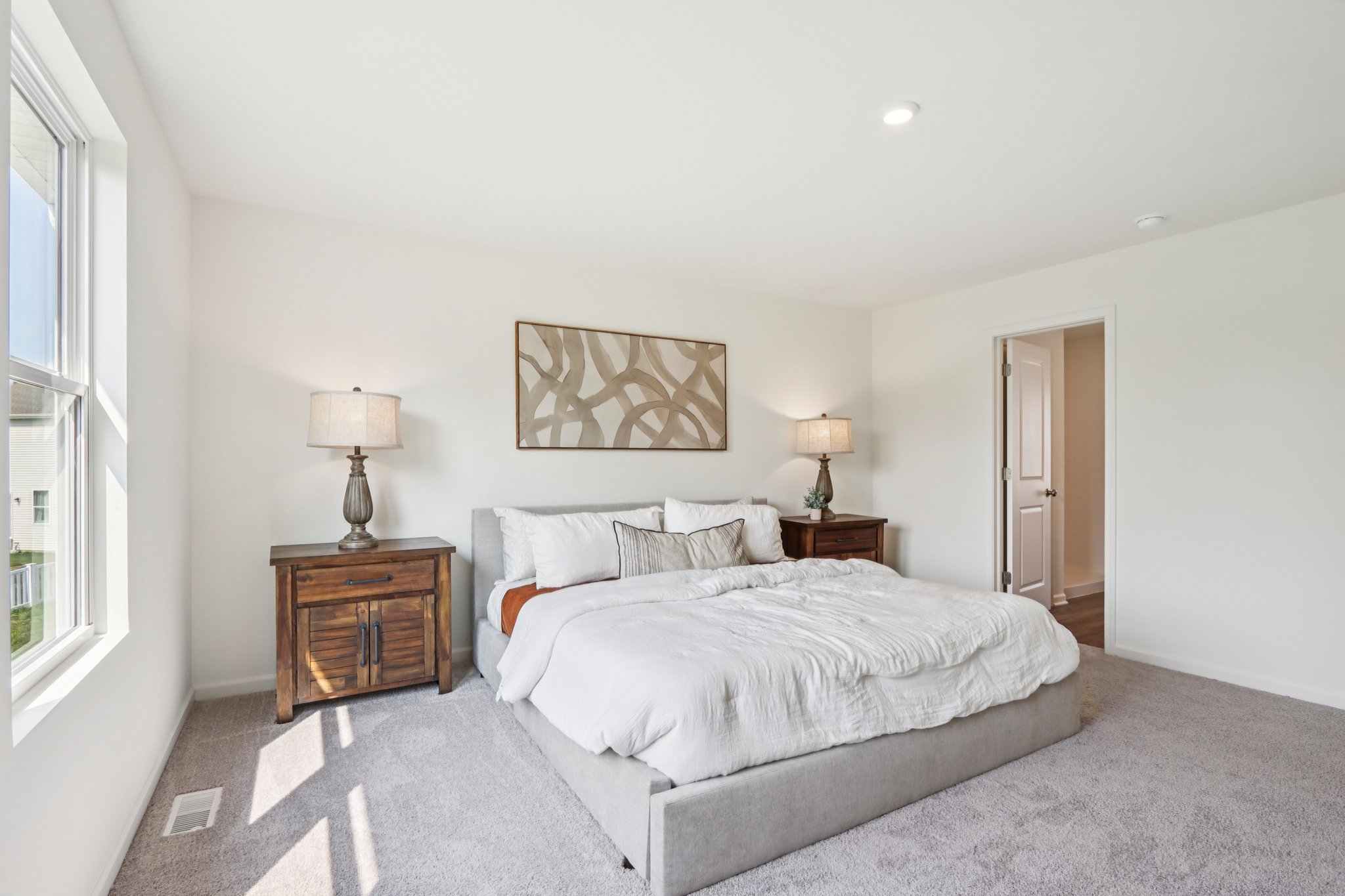 A bedroom with a bed and lamps.