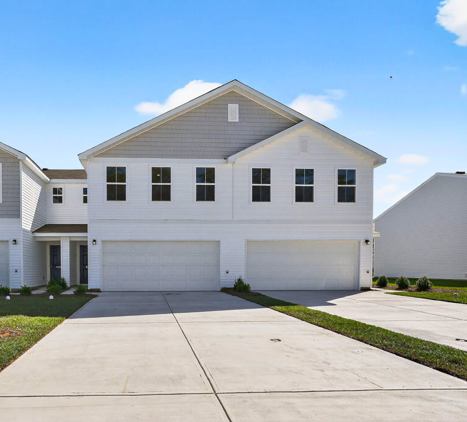 A white house with garages.