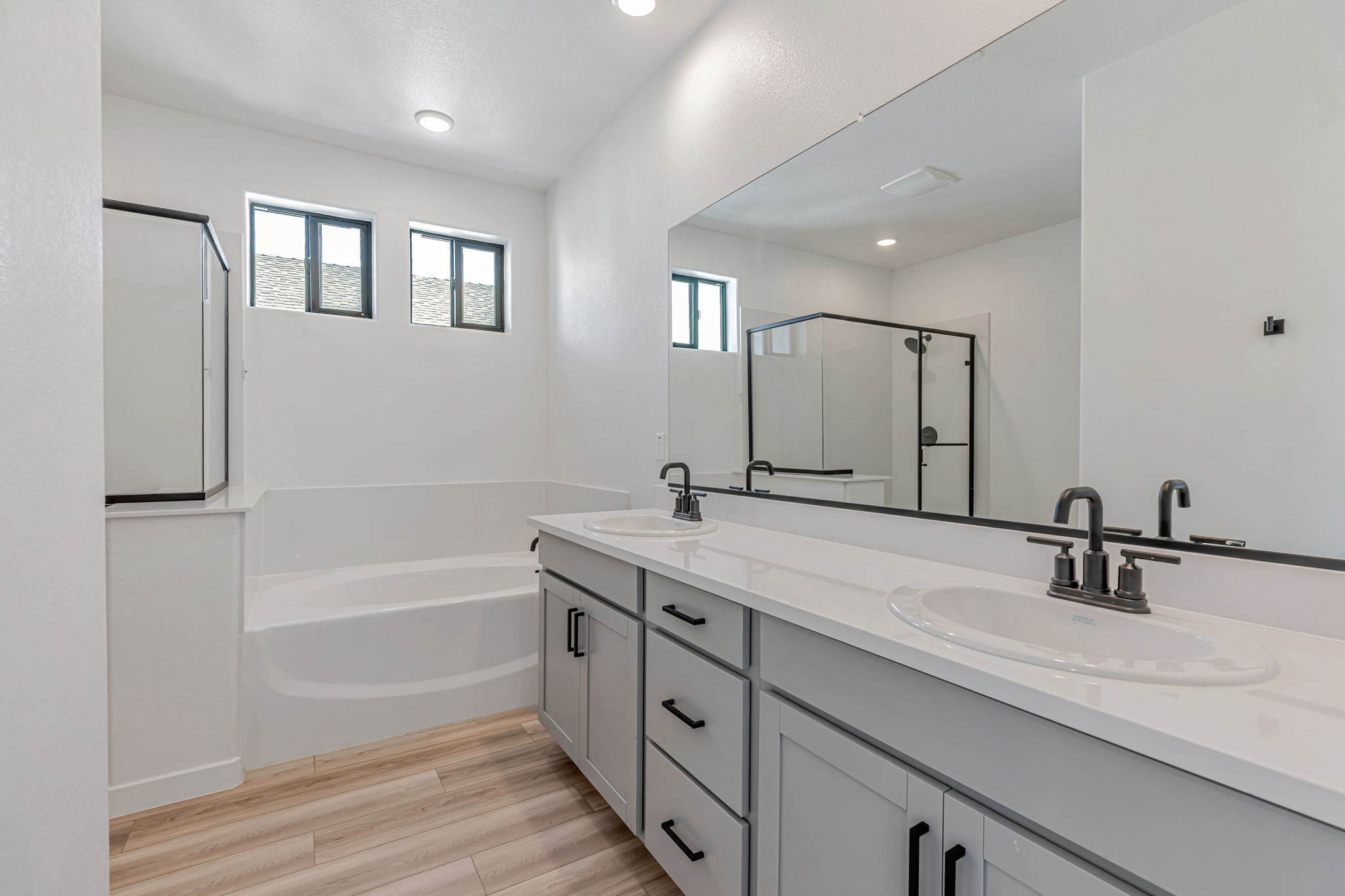 A bathroom with a tub sink and mirror.