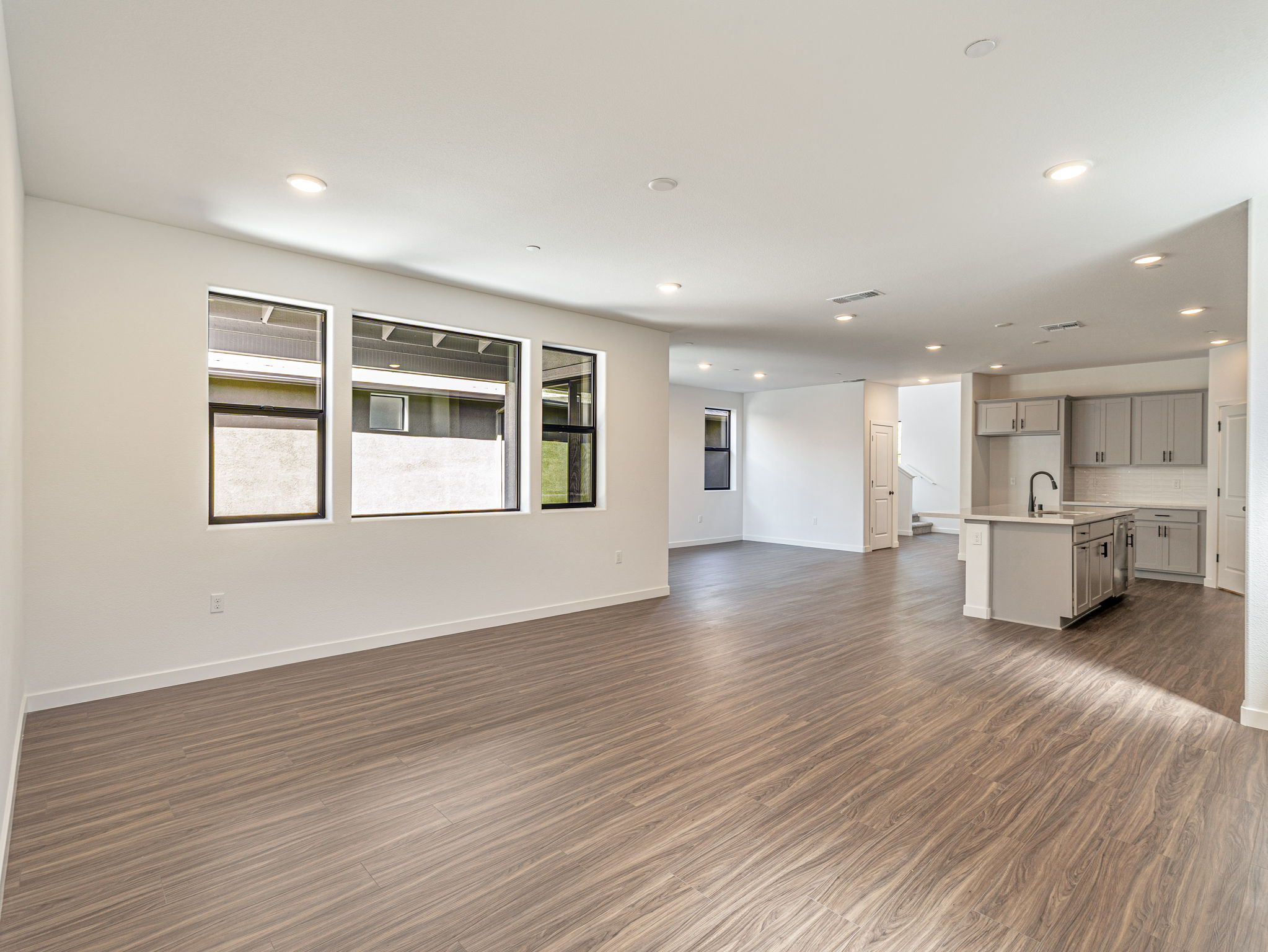 A large empty room with a wood floor and white walls.