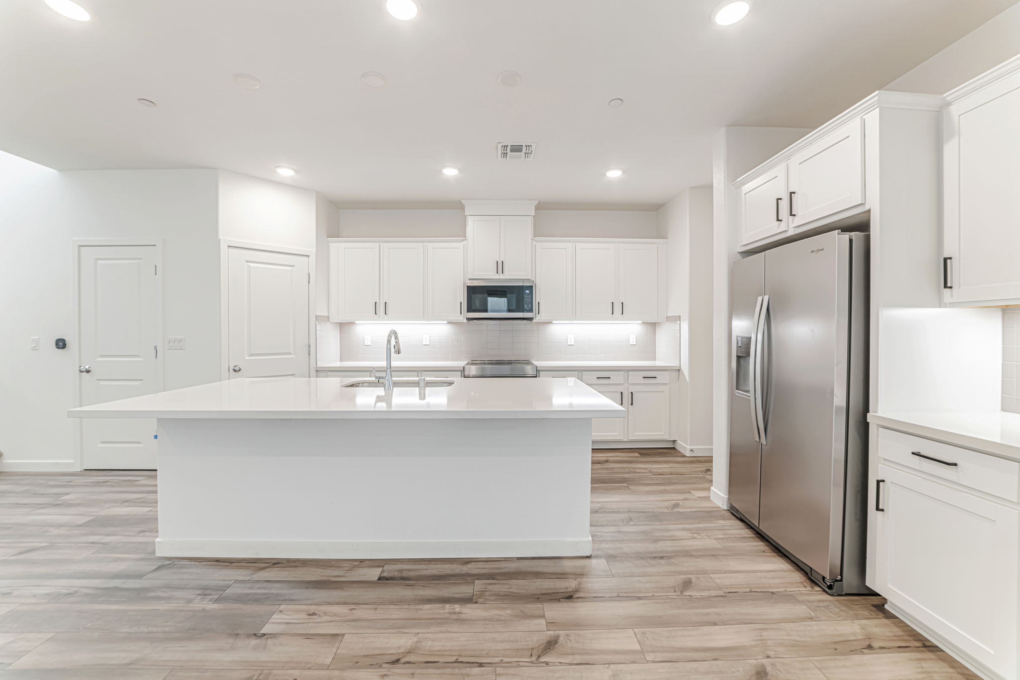 A kitchen with white cabinets.