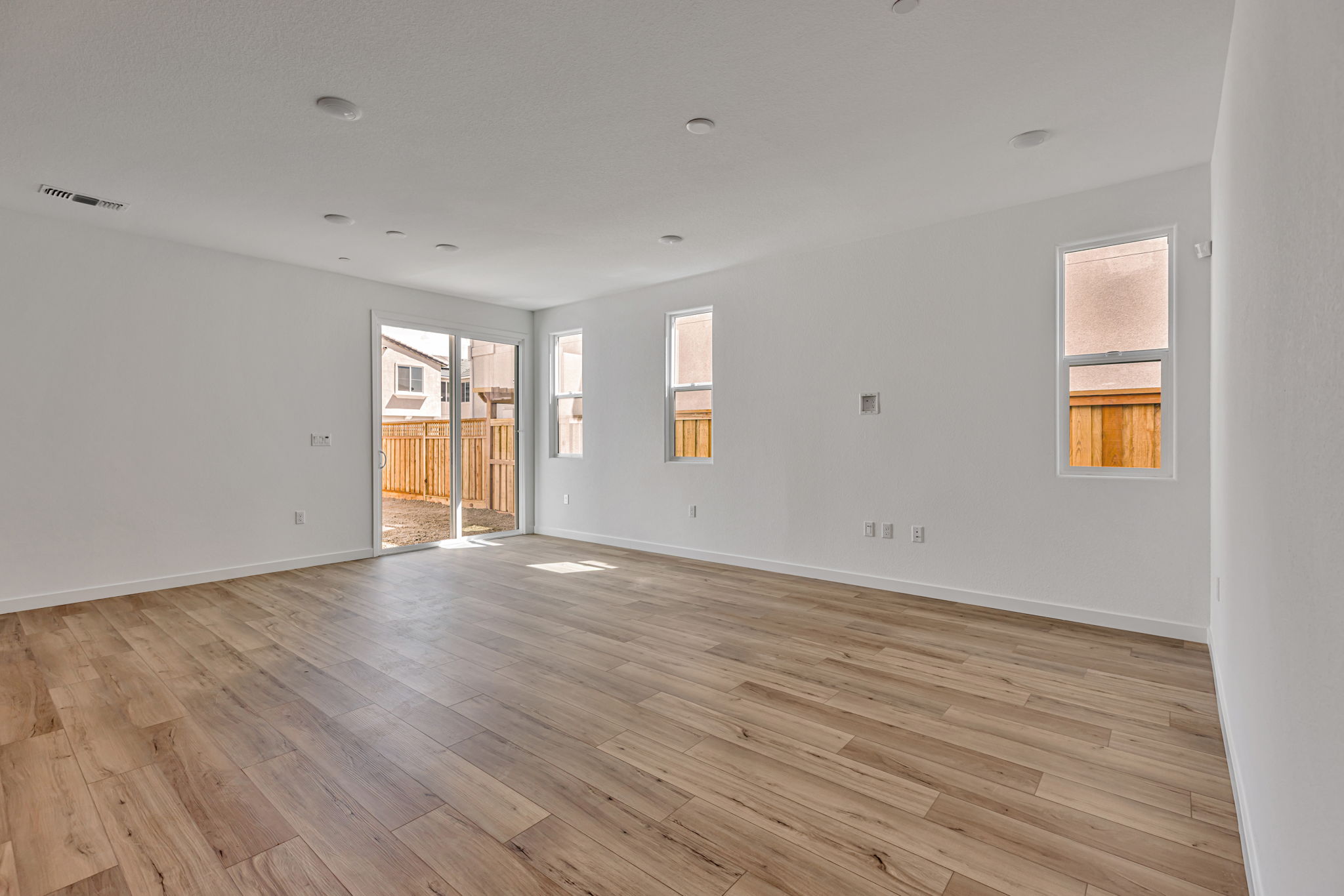 A room with a wood floor and windows.