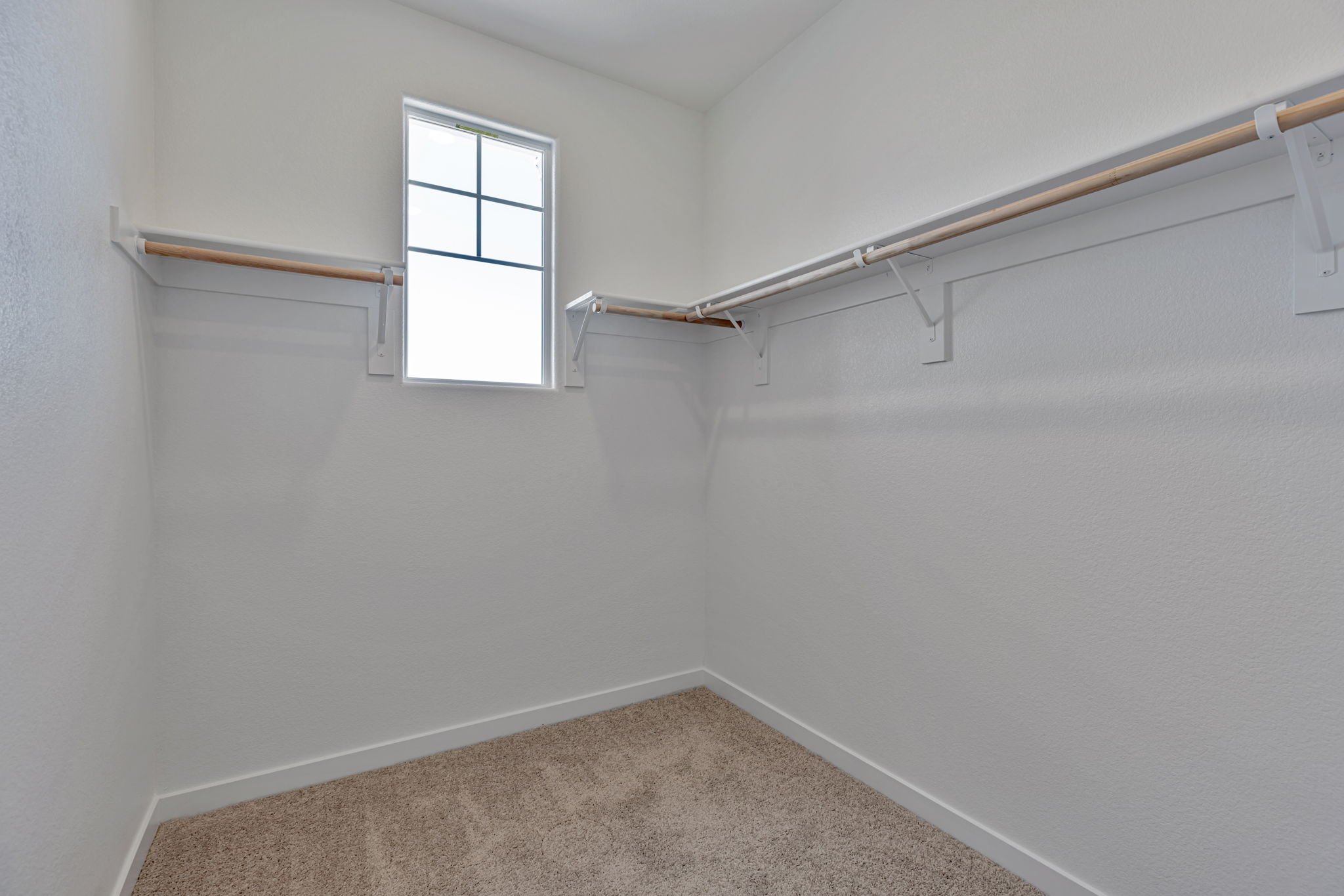 A room with a window and a carpet.