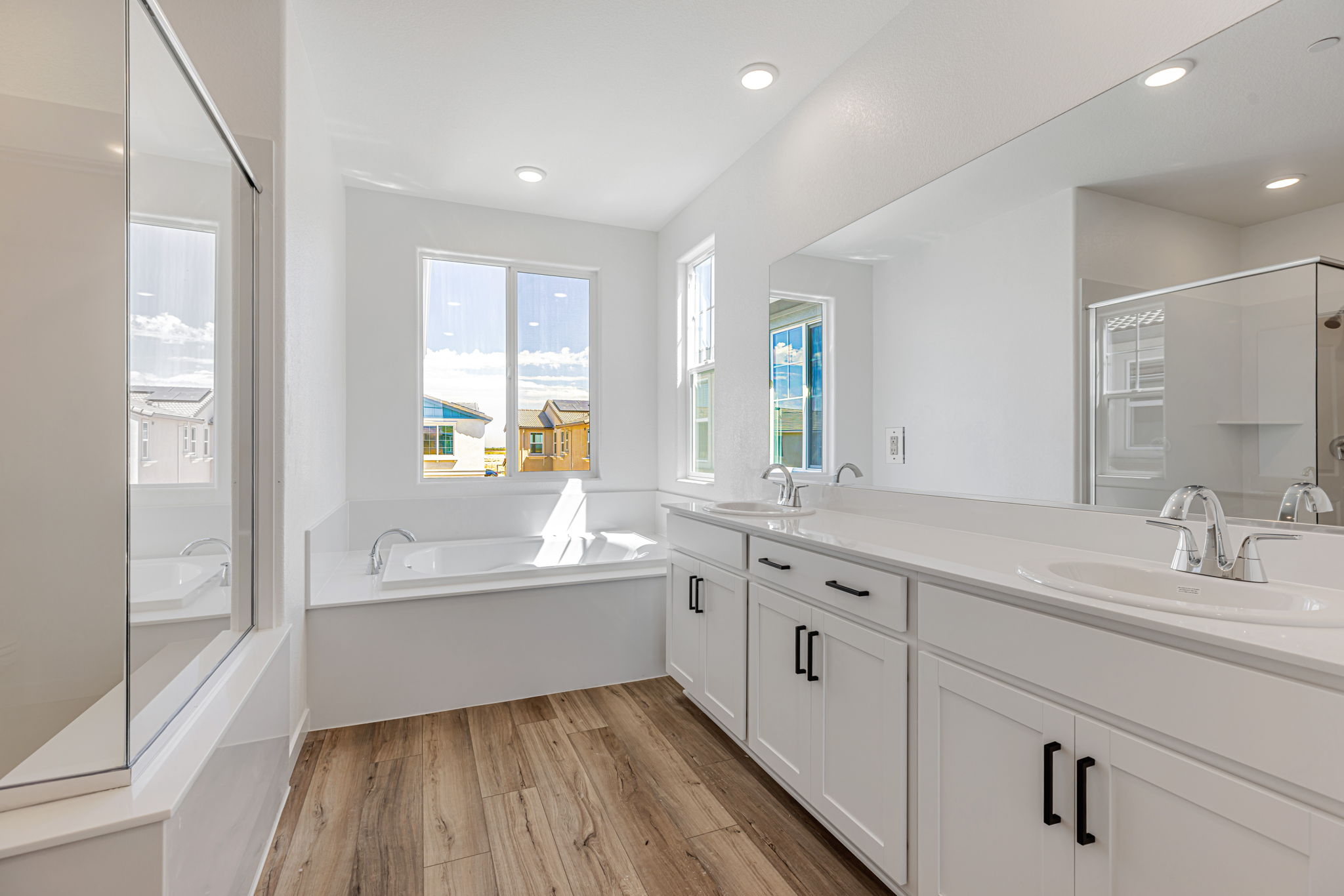 A bathroom with a tub sink and a mirror.